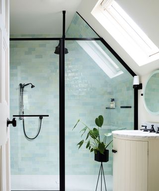 bathroom with pale blue tiles, glass shower doors and sink