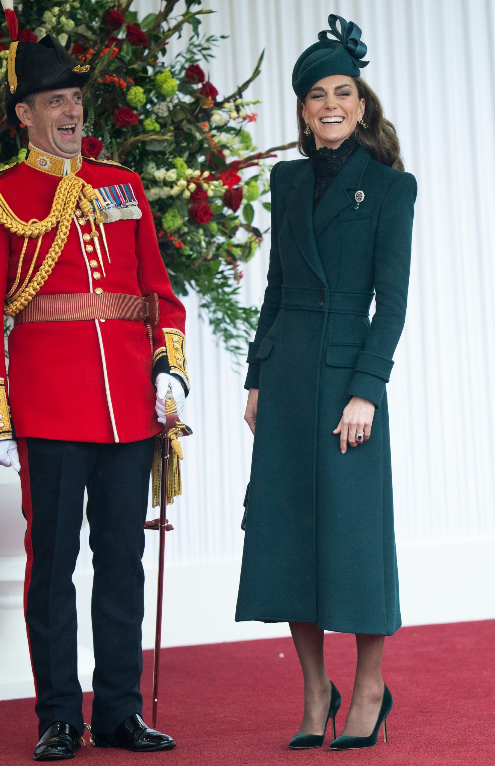 Princess Kate laughing next to a soldier wearing a red uniform