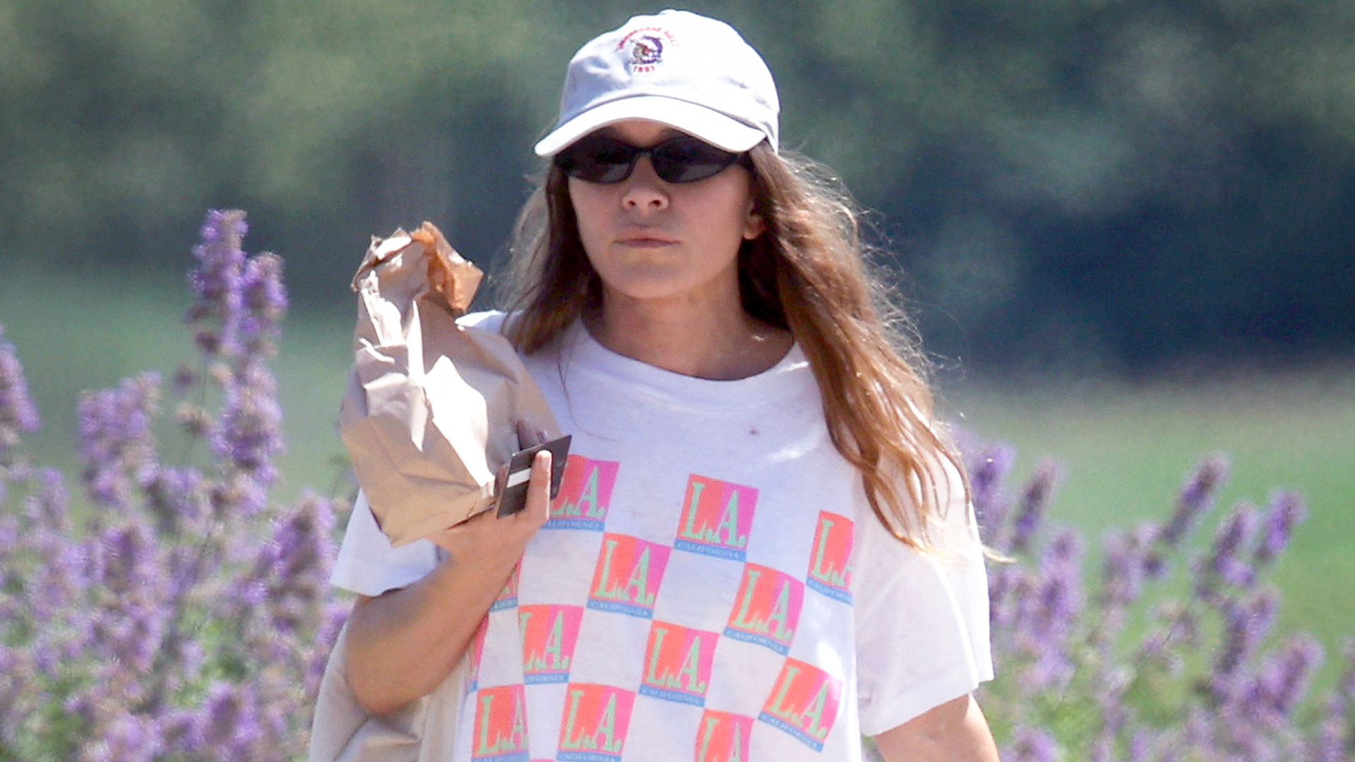 Mary-Kate Olsen walks in the Hamptons wearing a graphic t-shirt with sweatpants and flip flops