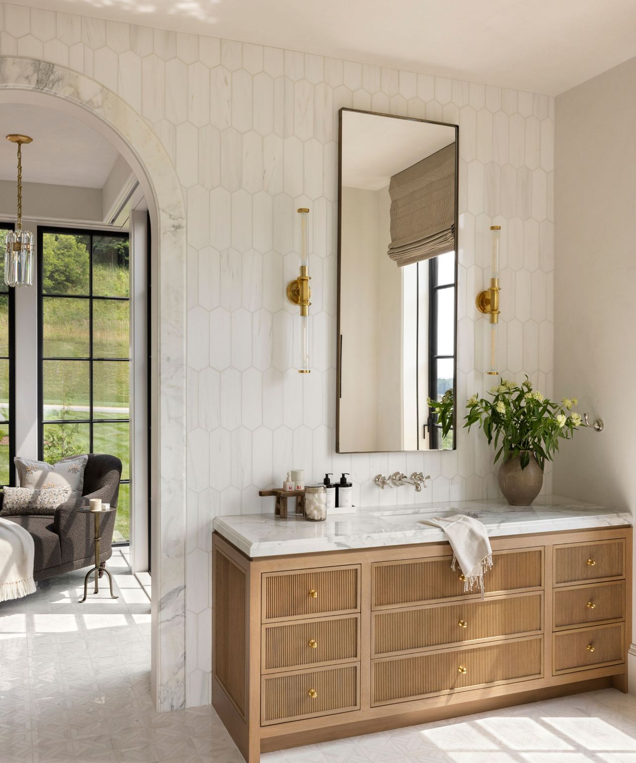 A neutral bathroom with a wooden vanity and a marble counter