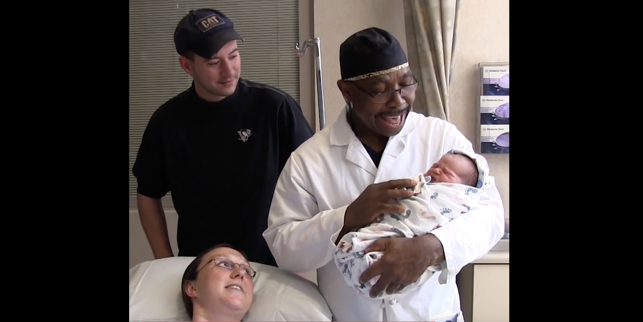 Dr. Carey Andrew-Jaja sings to a baby he delivered.