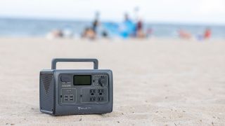 The BLUETTI EB55 battery sits on a beach