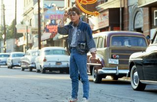 Michael J Fox walking across the street in a scene from the film 'Back To The Future', 1985.