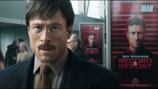 Glen Powell stands in disguise in front of his own wanted poster in The Running Man.