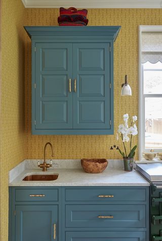 Blue and yellow kitchen with floral print wallpaper