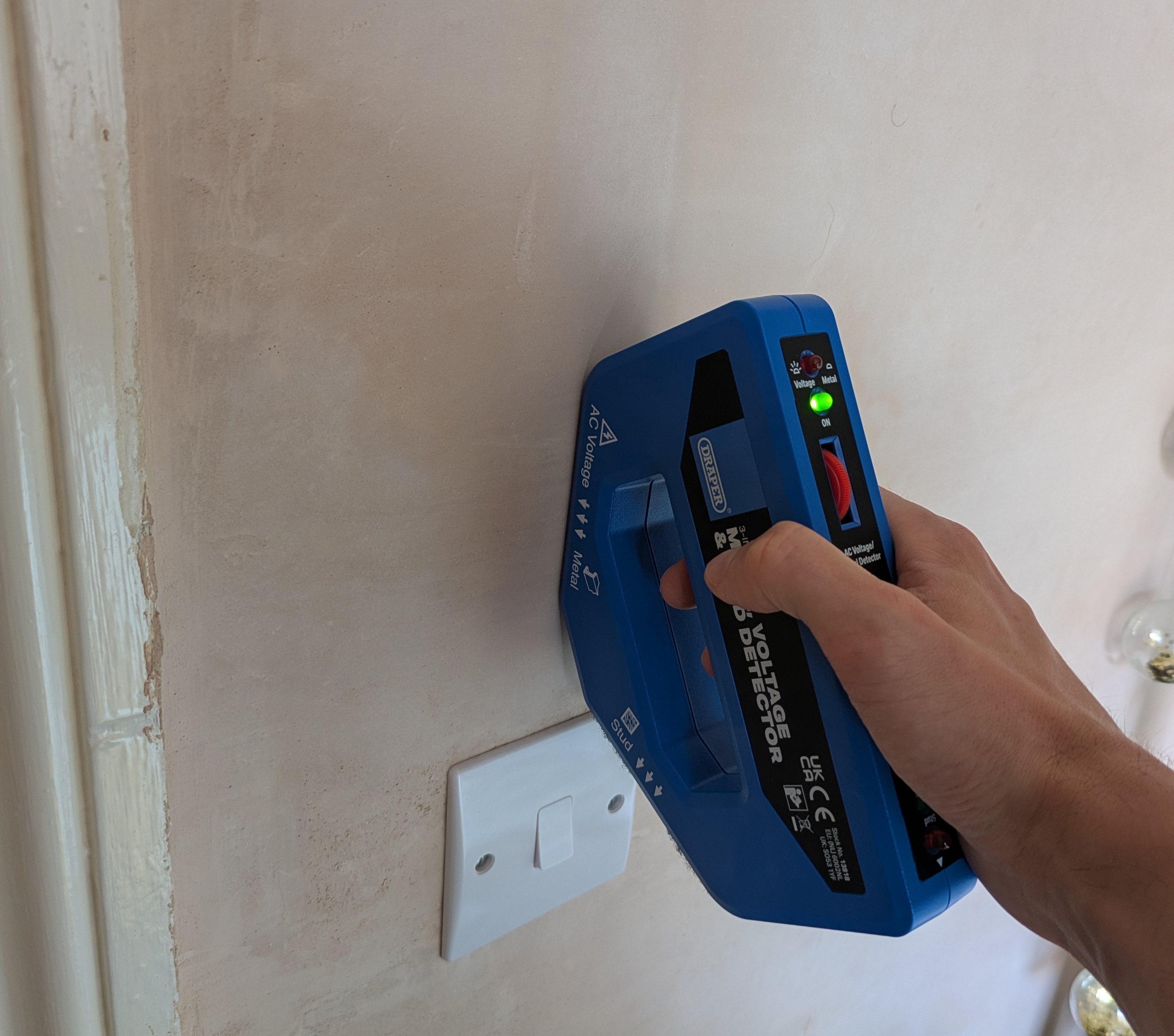Using a voltage detector to test voltage above a light switch