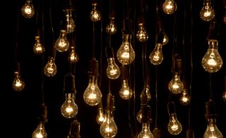 Many glowing light bulbs on a black background.