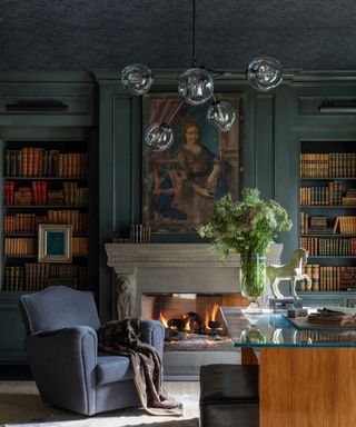 Green home library with armchairs and glass coffee table