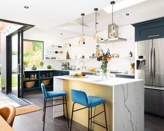 A modern kitchen with tray ceiling, open-plant layout and marble kitchen island