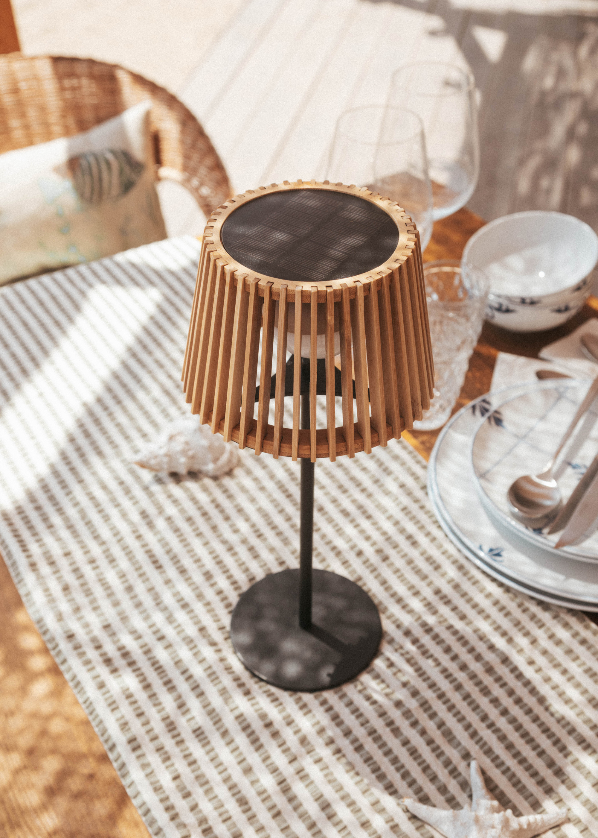 A table lamp with a wood shade and a metal stem