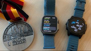Berlin Marathon medal, Apple Watch Ultra, Garmin Epix 2 in a line