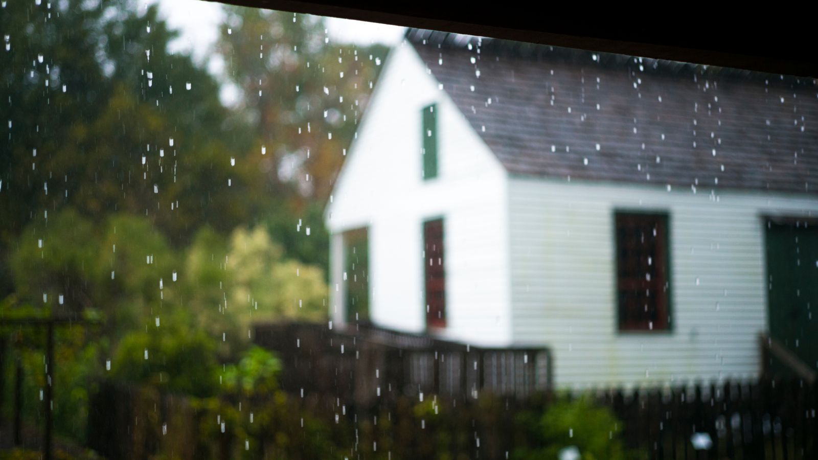Rain falling in front of a white farmhouse