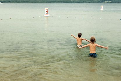 Boys swimming in a lake.