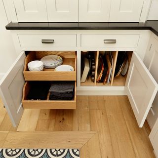 room with wooden floor tray dishes in inner cupboards