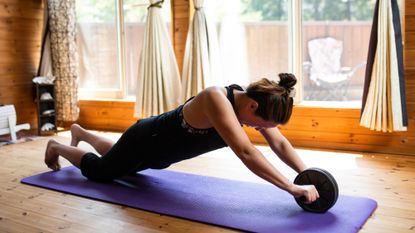 Woman using an ab roller to work her core