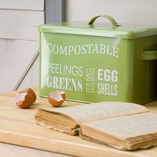 Green compost bin on a wood table