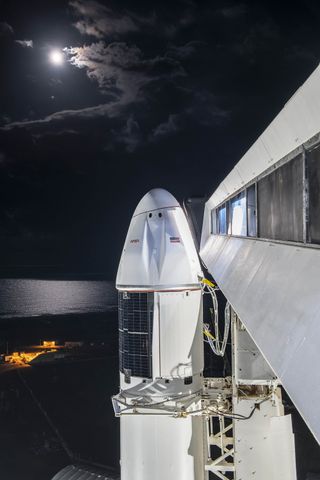 SpaceX's Cargo Dragon for the CRS-24 resupply mission for NASA stands atop its new Falcon 9 rocket with a bright moon in the background ahead of a planned Dec. 21, 2021 launch from Pad 39A of NASA's Kennedy Space Center in Florida.