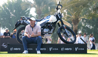 Rory McIlroy sits by a motorbike whilst he waits for the green to clear