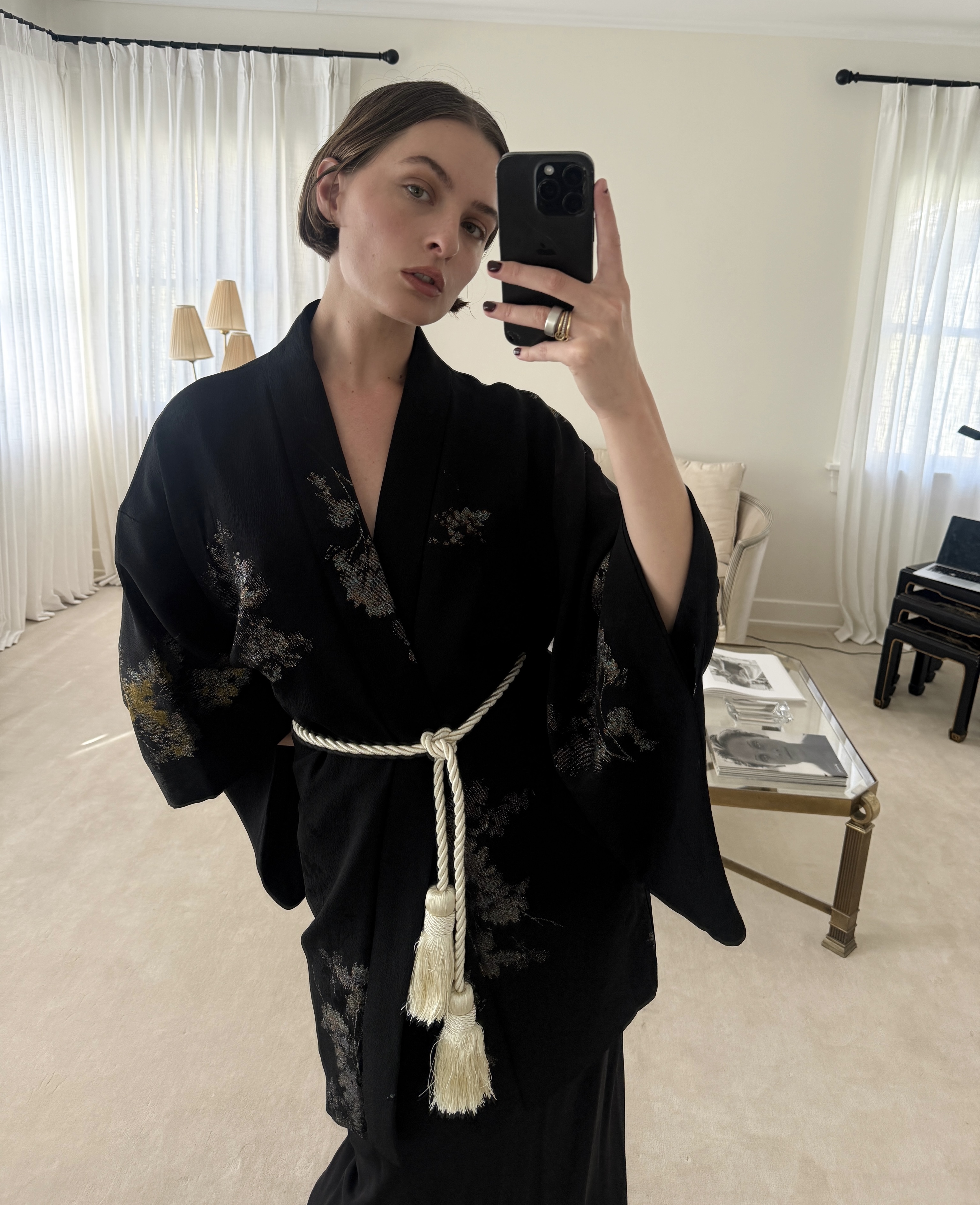 Half-length mirror selfie of Christie Tyler wearing a tassel belt over a kimono-style dress