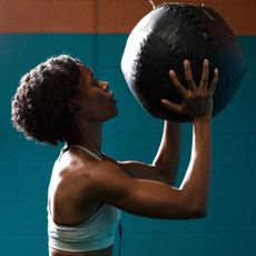 Shoulder workouts: A woman lifting a weighted ball
