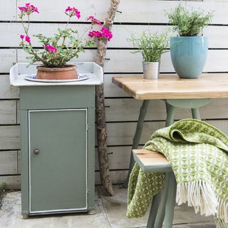 garden area with wooden table and potted plants