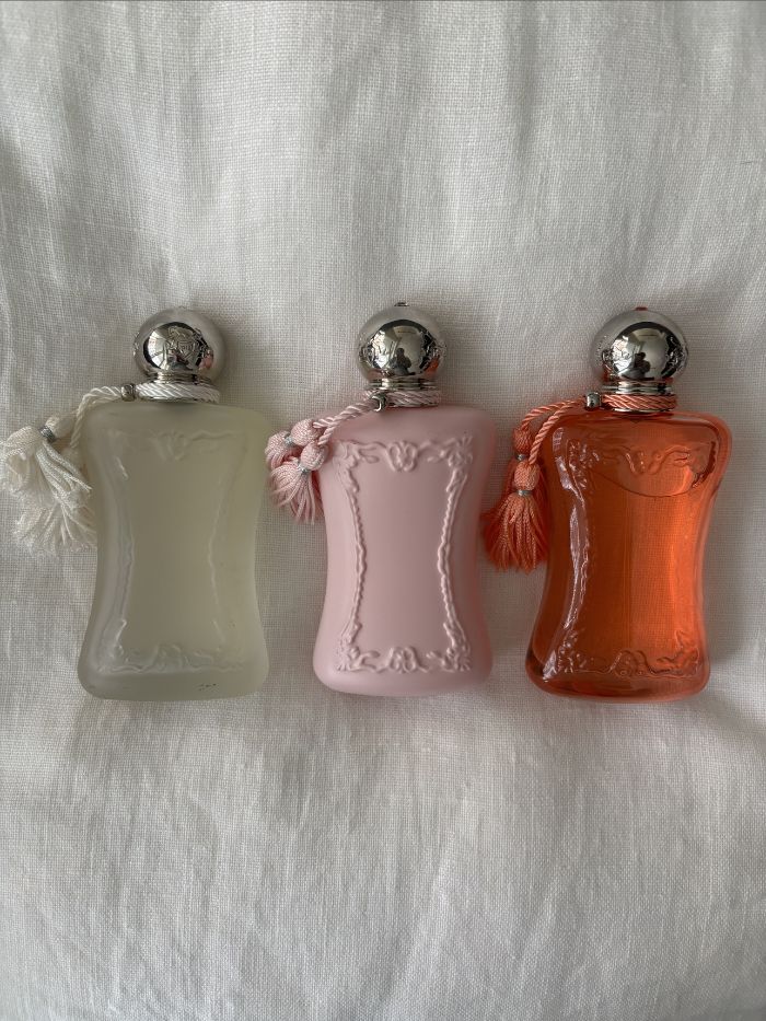 Three Parfums de Marly perfumes on a white linen background