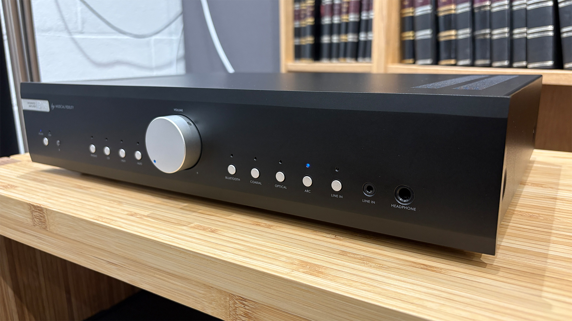 Musical Fidelity B1xi integrated amplifier on wooden hi-fi rack in front of bookcase