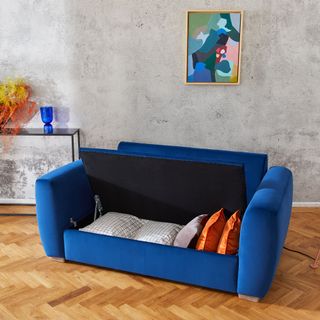 room with wooden floor and tight door for blue sofa