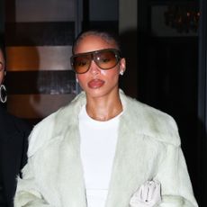 Lori Harvey wearing a coat, white t-shirt, plaid pants, and pointed toe heels