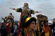 A man dressed as one of the Three Kings greets people during the Epiphany parade in Gijon, Spain.