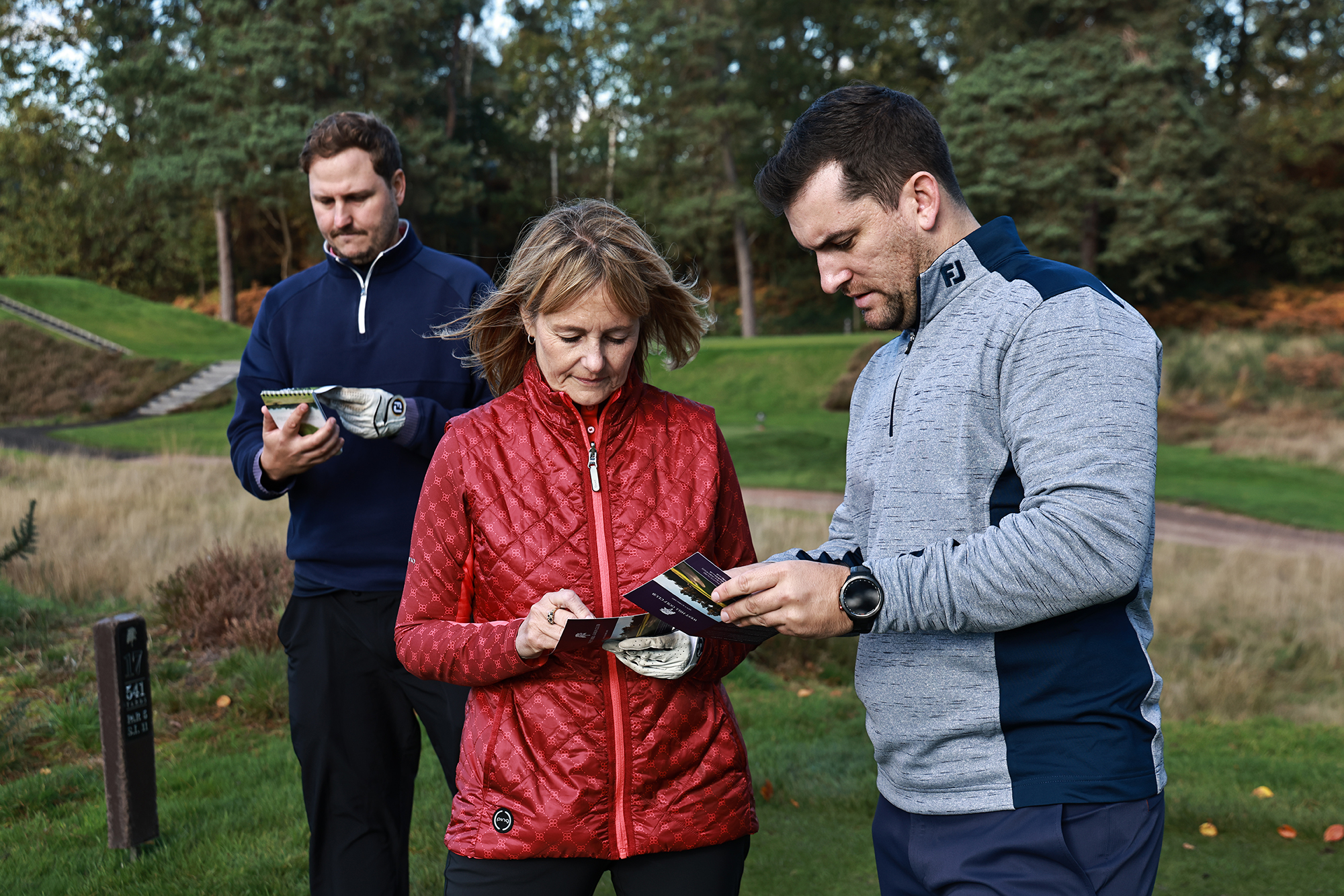 Sam De'Ath, Alison Root and Nick Bonfield completing scorecards as part of a golf competition