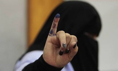 A woman shows her ink-stained finger after casting her vote in Cairo: A run-off election will likely be held in June since none of the 12 presidential candidates is expected to win a majority