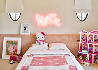 girl's room with white walls and pink oversized headboard