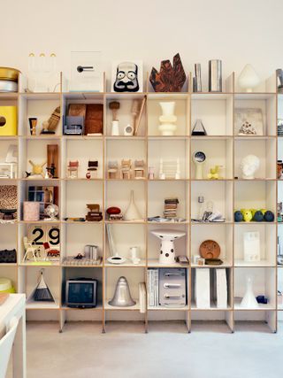 Inspirational ephemera, material samples, and project models and prototypes adorn shelves in the lower floor studio