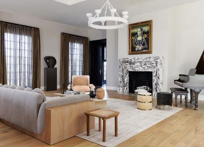 should a sofa face the door; neutral living room with boucle sofa and marble fireplace by Ryan Saghian