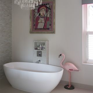 bathroom with white bathtub and flamingo statue