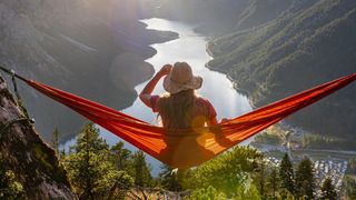 Woman looking out across a lake from a hammock