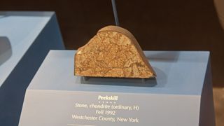 A brown/orange rock on display is a fragment of the Peeskill meteorite.