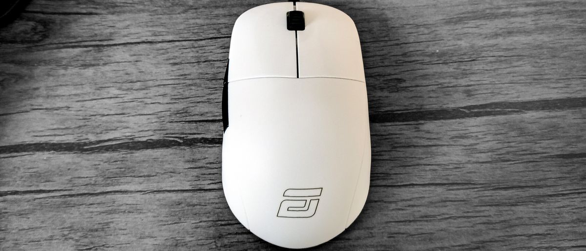 A white Endgame Gear XM1r gaming mouse on a wooden table