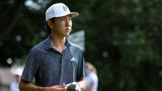 Jay Leng Jr walks off the green taking his glove off