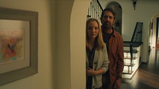 lisa kudrow as lydia and ray romano as paul peering around the corner in a home in no good deed