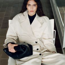 Woman wears cream trench coat 