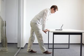 A man standing up at a desk.