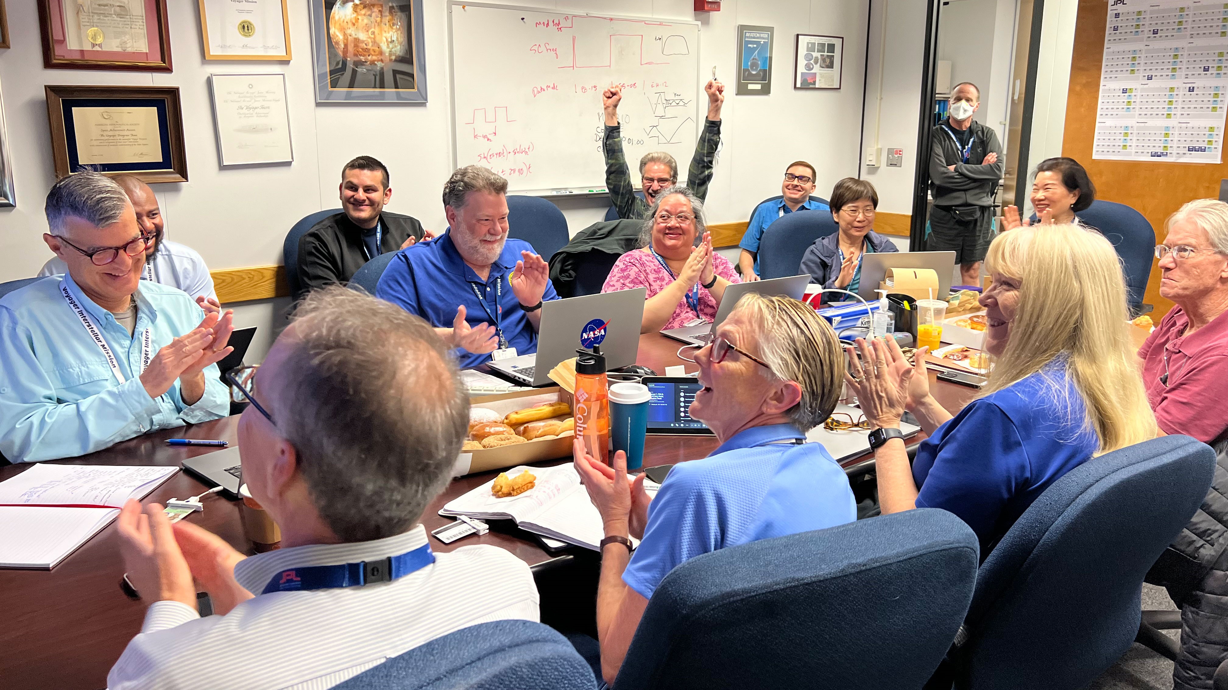 NASA engineers celebrate after receiving data from Voyager 1.