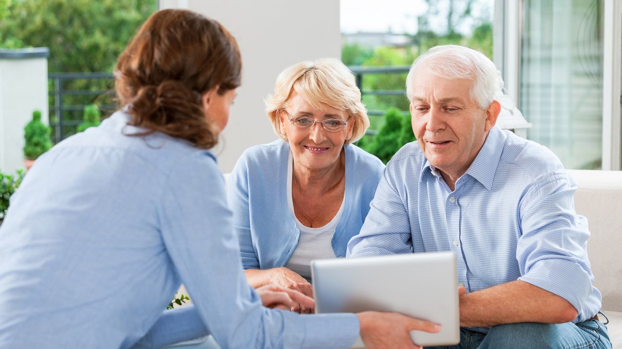 A senior couple sits with a financial adviser.