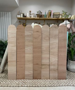 Ten pieces of scallopped wood panels assembled together to make DIY headboard