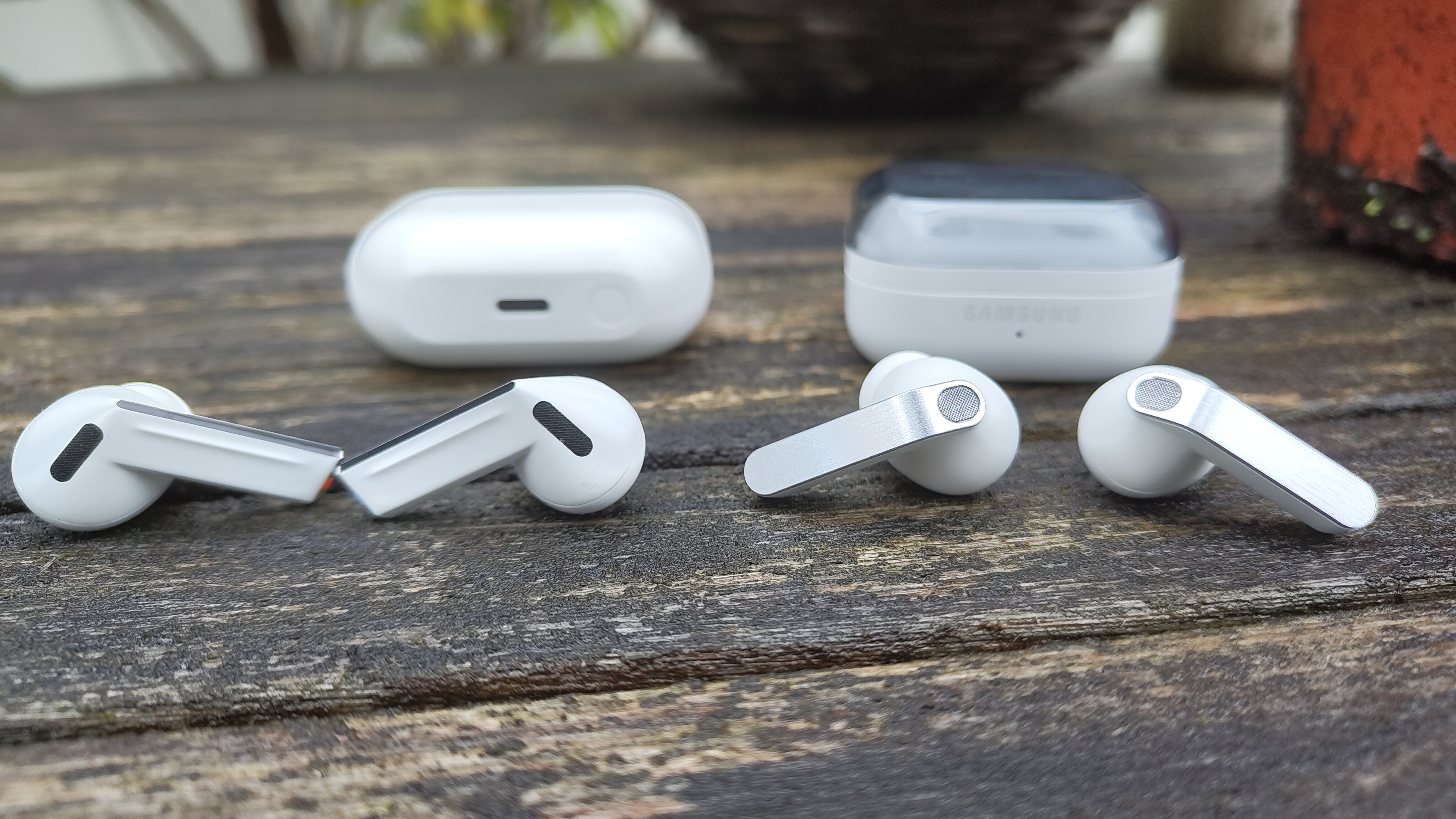 Samsung Galaxy Buds 3 Pro and Buds 4 Pro wireless earbuds next to each other on wooden desk