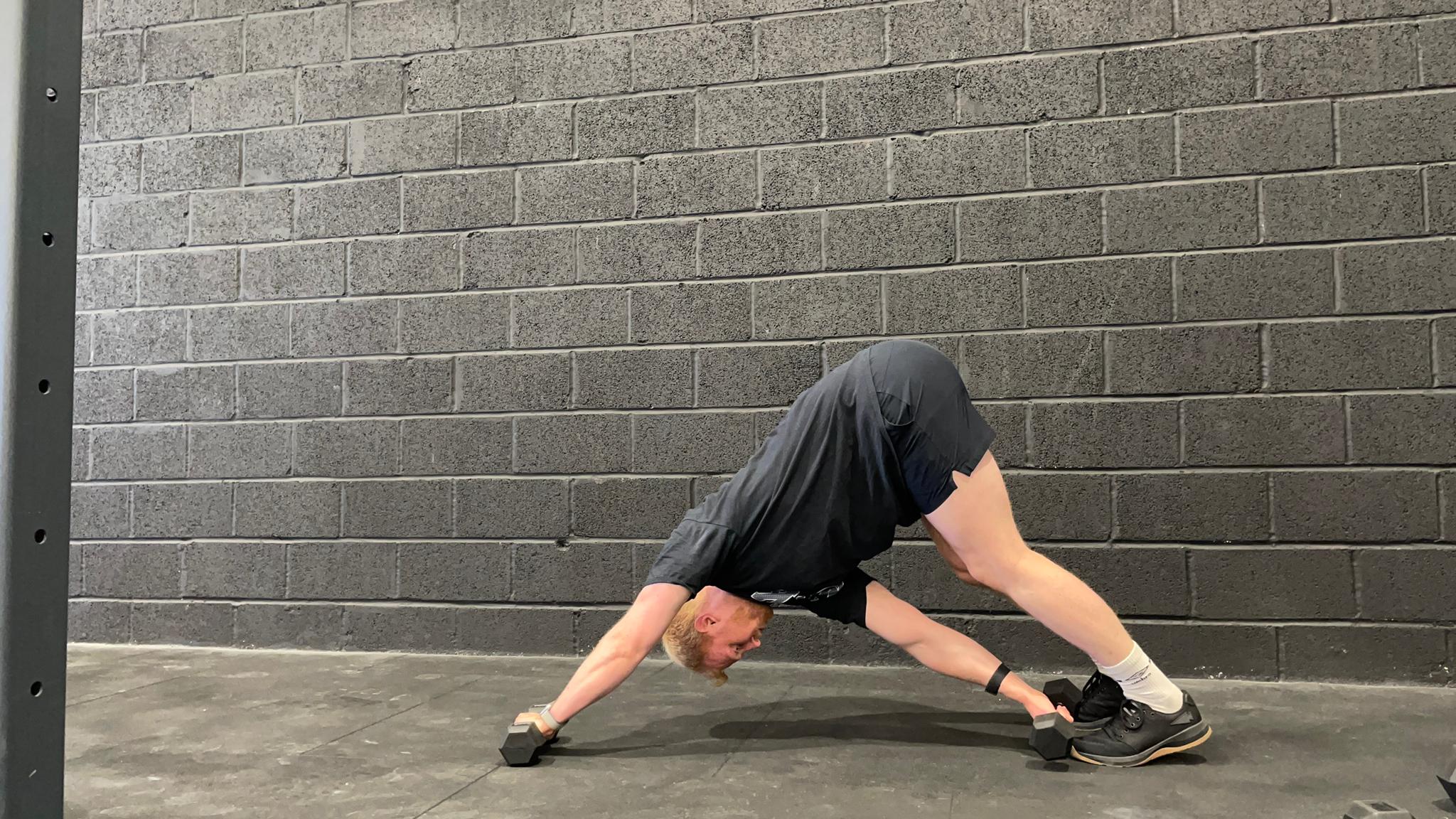 TechRadar fitness writer Harry Bullmore demonstrating a dumbbell pyramid plank switch