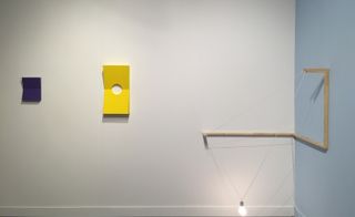 wall-mounted wedge sculptures and a minimalist lighting fixture by Noam Rappaport