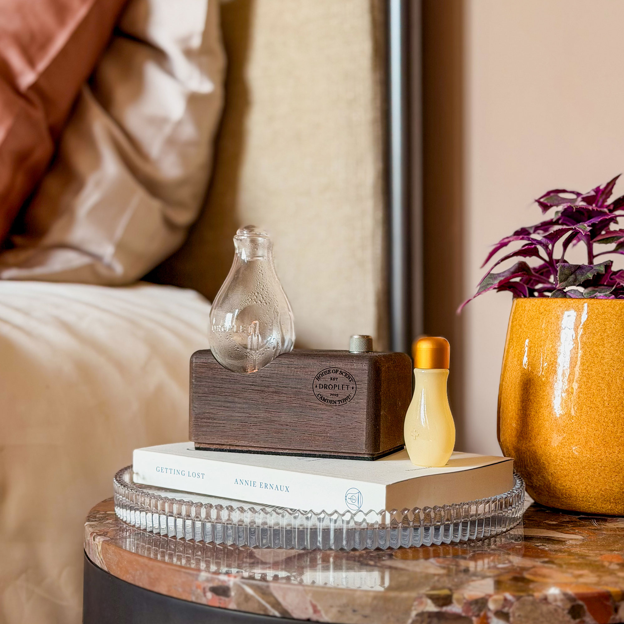 Small objects sitting on books on stone topped bedside table